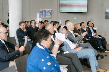 Menschen sitzen im Publikum und schauen zur Bühne